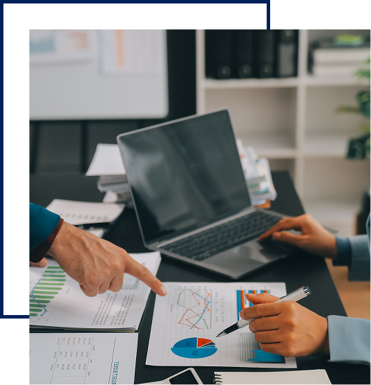 Two professionals collaborating over data reports and charts